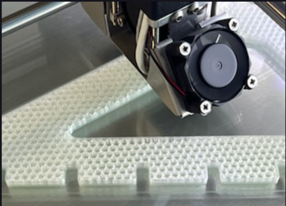 thread holder side printed in clear plastic with honeycomb patternining, showing the printer head